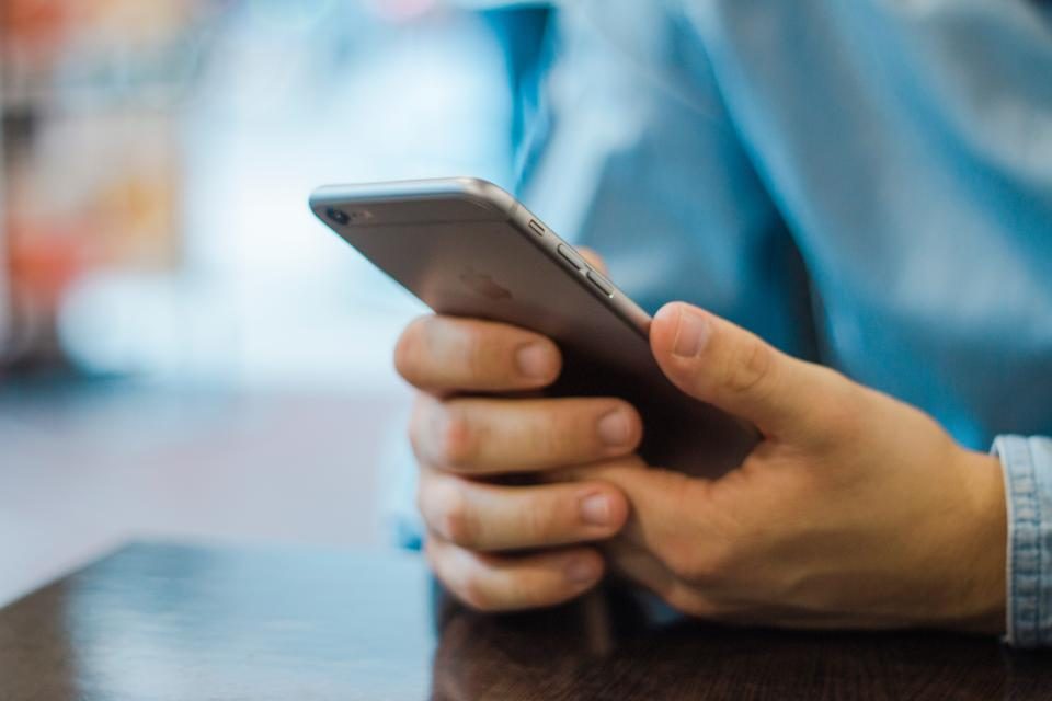 Hands holding a phone over a table