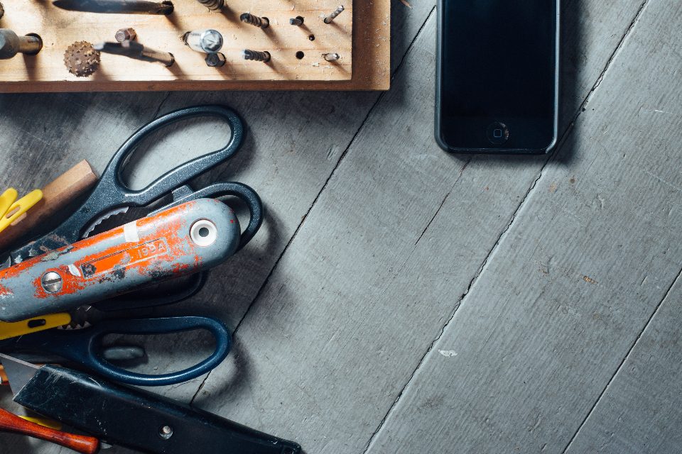 Tools and a phone laid out on a workbench