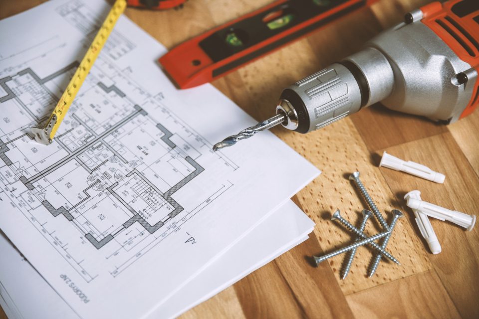 House plans with a measuring tape and a drill