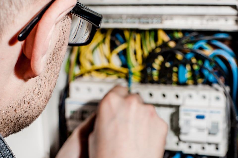 An electrician working inside a switchboard